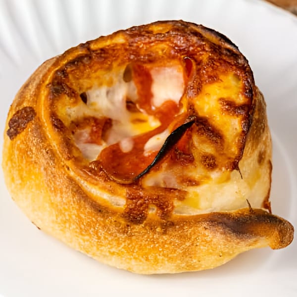 A golden-brown, baked pizza roll from Phil's Pizzeria, filled with melted cheese and pepperoni.