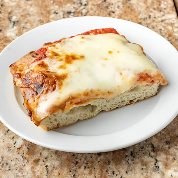 A thick slice of Phil's Pizzeria's cheese pizza with melted mozzarella and red sauce.