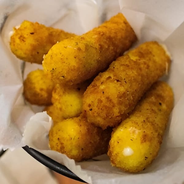 Golden-brown mozzarella sticks, some with melted cheese peeking out, served in a white paper-lined basket.